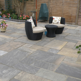 Luxury Garden With Seating Area And Natural Riven Patio Paving Slabs in Classicstone Graphite